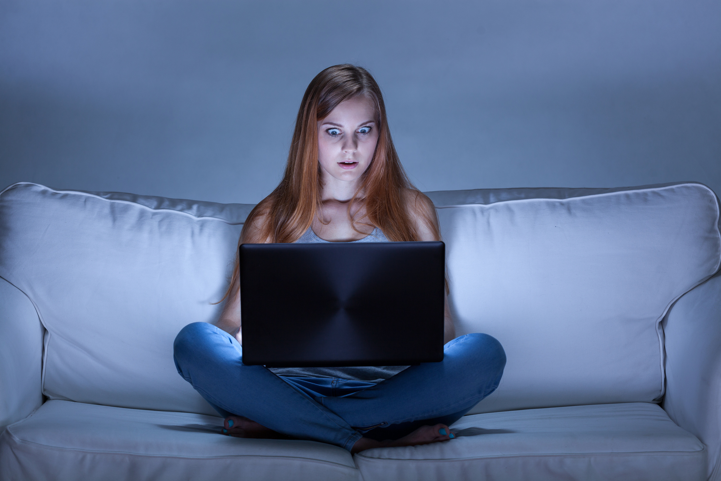 Shocked girl using facebook at night
