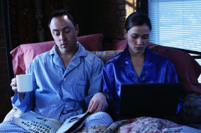 Business Couple Working in Bed